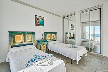 A bedroom with two twin beds and a mirrored wardrobe