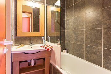 A bathroom with a sink a bathtub and a mirror