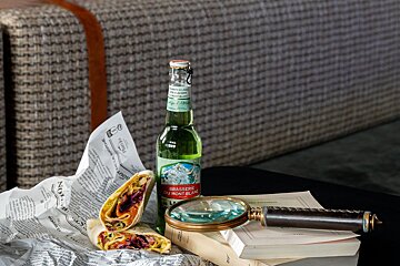 A bottle of brasserie du mont blanc sits on top of a book
