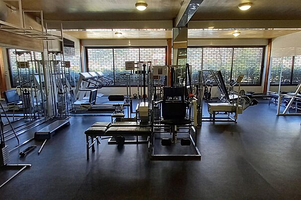A gym with a lot of exercise equipment including a treadmill