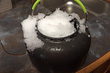 a kettle filled up with snow