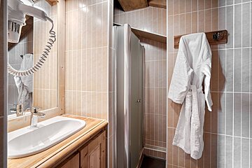 A bathroom with a white robe hanging on a hook