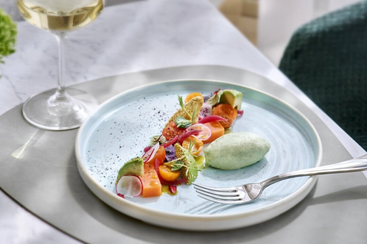 A plate of food with a fork and a glass of wine