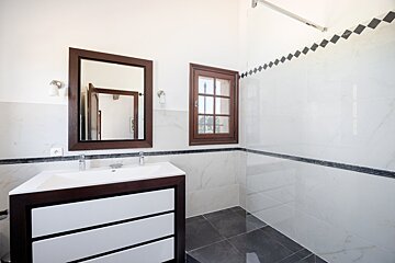 A bathroom with a sink a mirror and a window