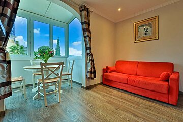 A living room with a red couch and a table