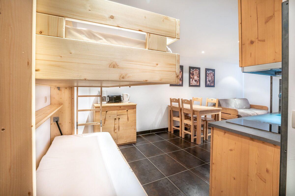 A bedroom with a bunk bed and a table and chairs