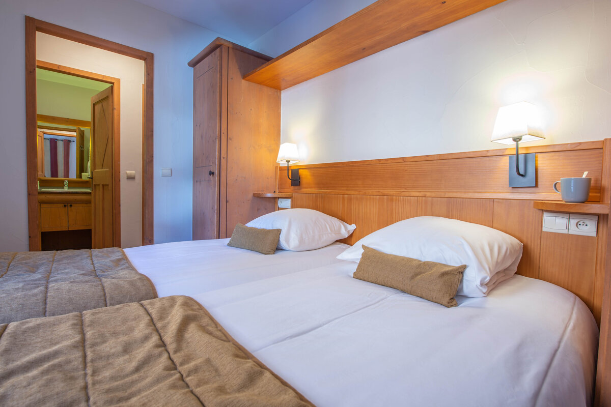 A hotel room with two beds and a bathroom