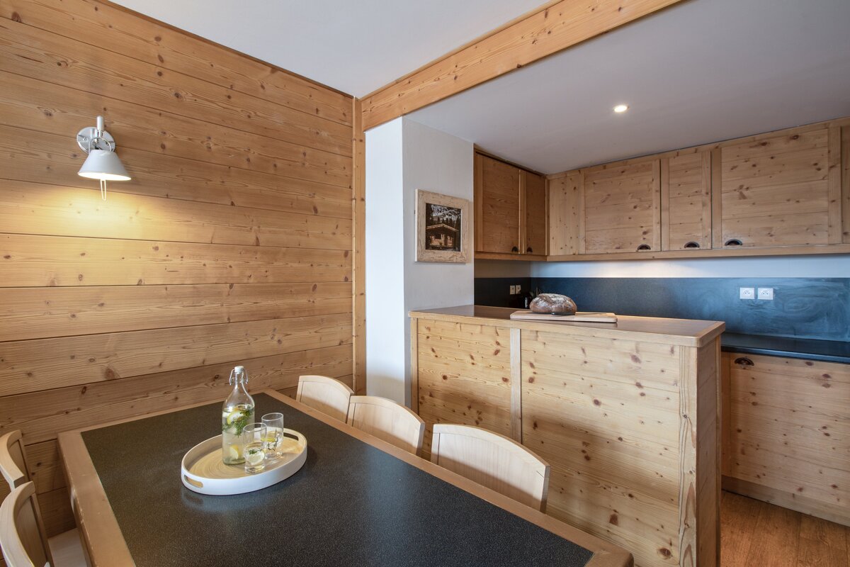 A bottle of wine sits on a table in a kitchen