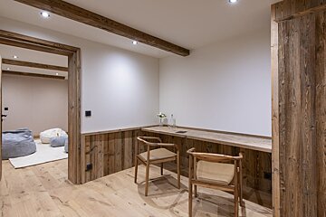 A wooden desk with two chairs in a room