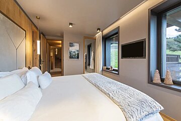 A bedroom with a large bed and a flat screen tv