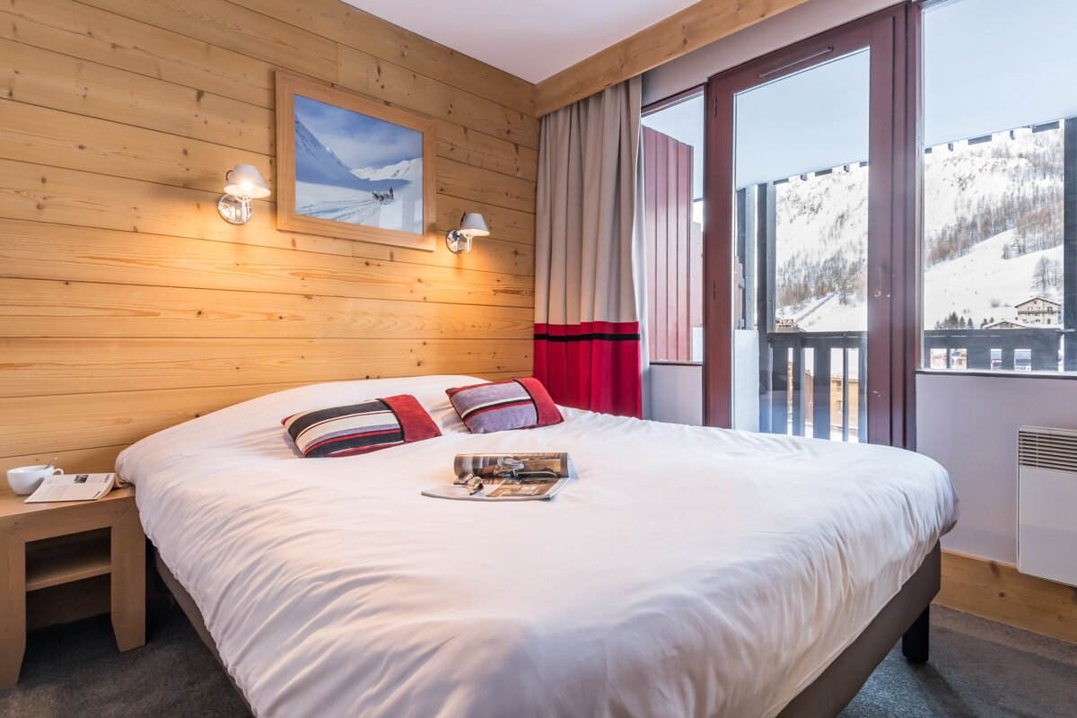 A bed with a magazine on it in a hotel room