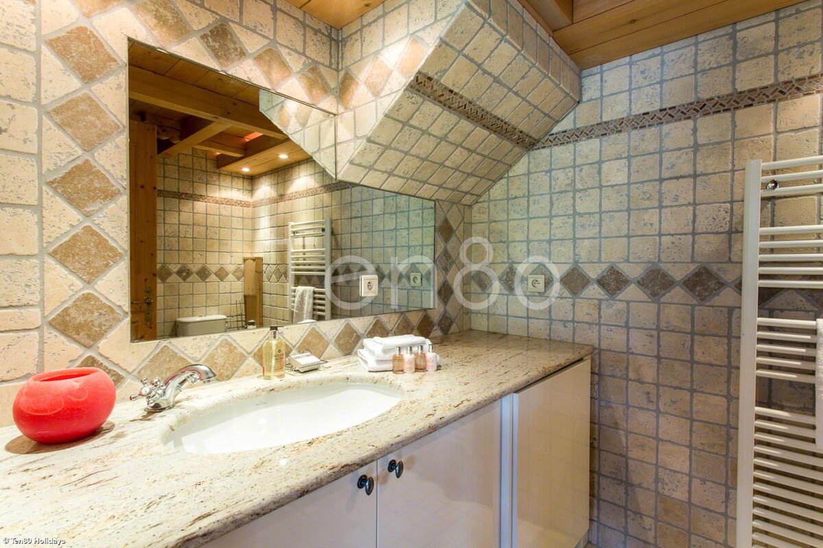 A bathroom with a sink and a mirror with the number 80 on the wall