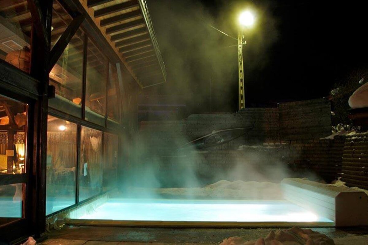 A large swimming pool is lit up at night