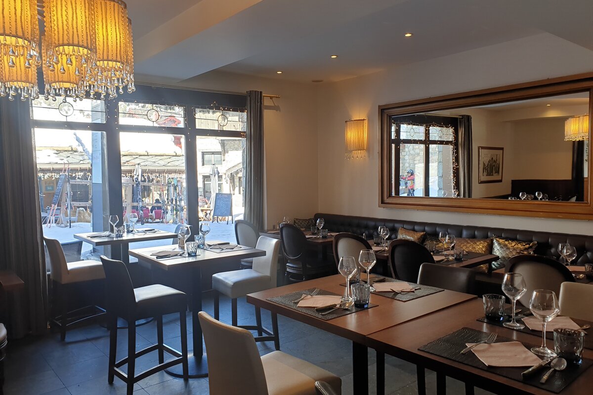 A restaurant with tables and chairs and a large mirror