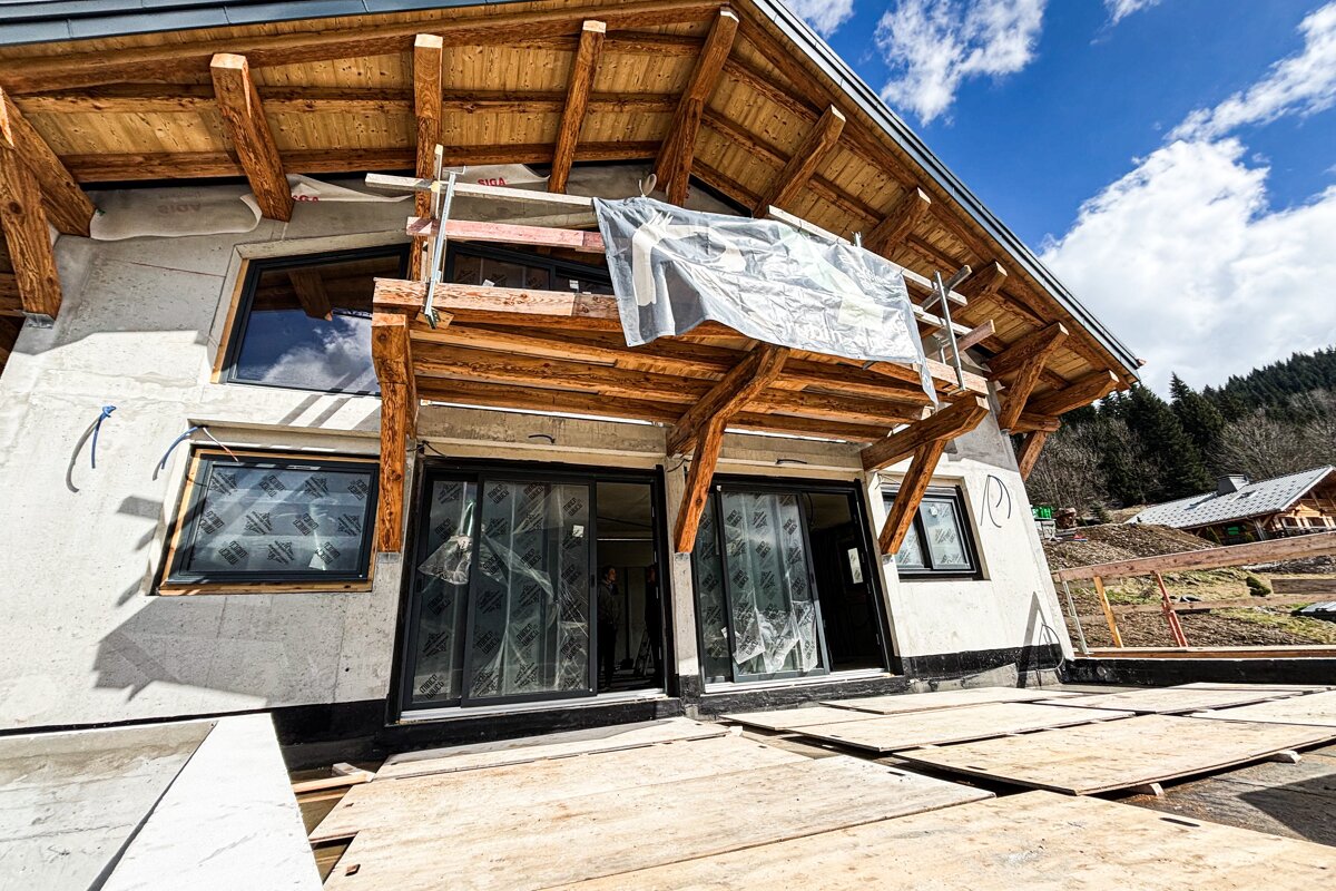 A building under construction with a sign hanging from the roof