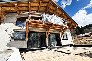 A building under construction with a sign hanging from the roof