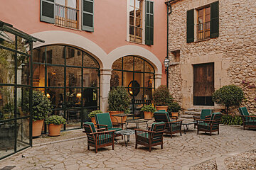 A patio with chairs and tables in front of a building