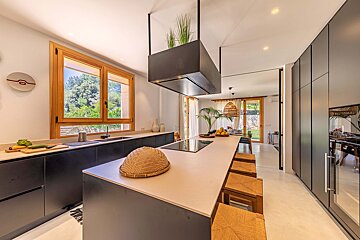 A kitchen with black cabinets and white counter tops