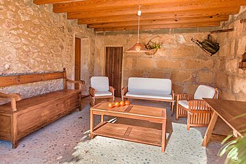 A living room with a couch and chairs and a table with oranges on it