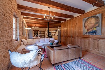 A living room with a couch and chairs and a painting on the wall