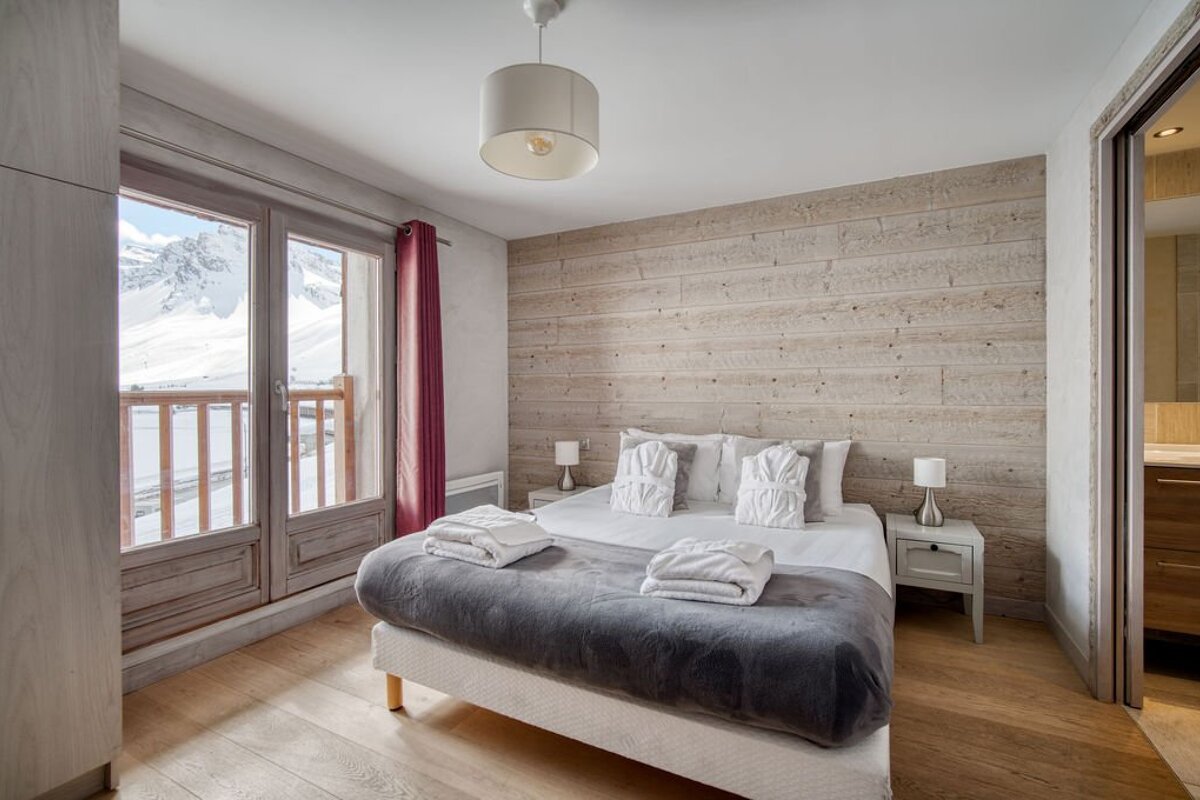 A bedroom with a large bed and a balcony