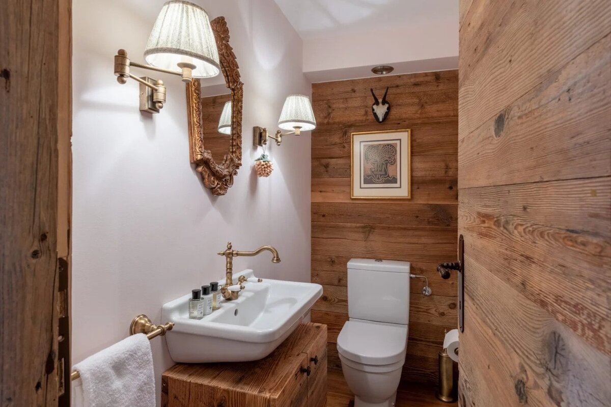 A bathroom with a wooden wall and a toilet