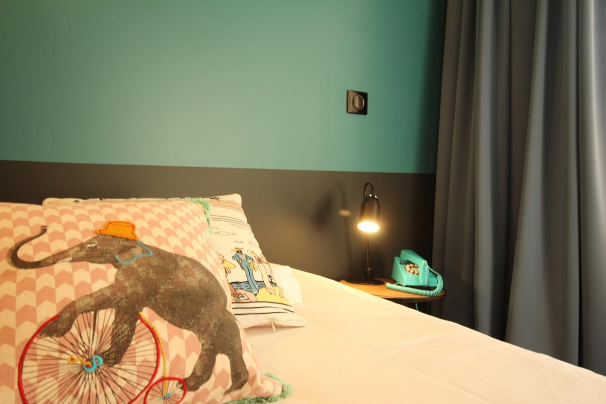 A bed with a pillow with an elephant on it