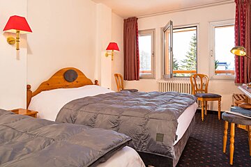 A hotel room with two beds and a window