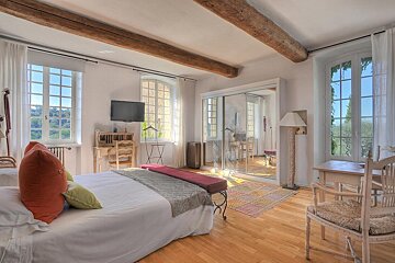 A bedroom with a large bed and a flat screen tv