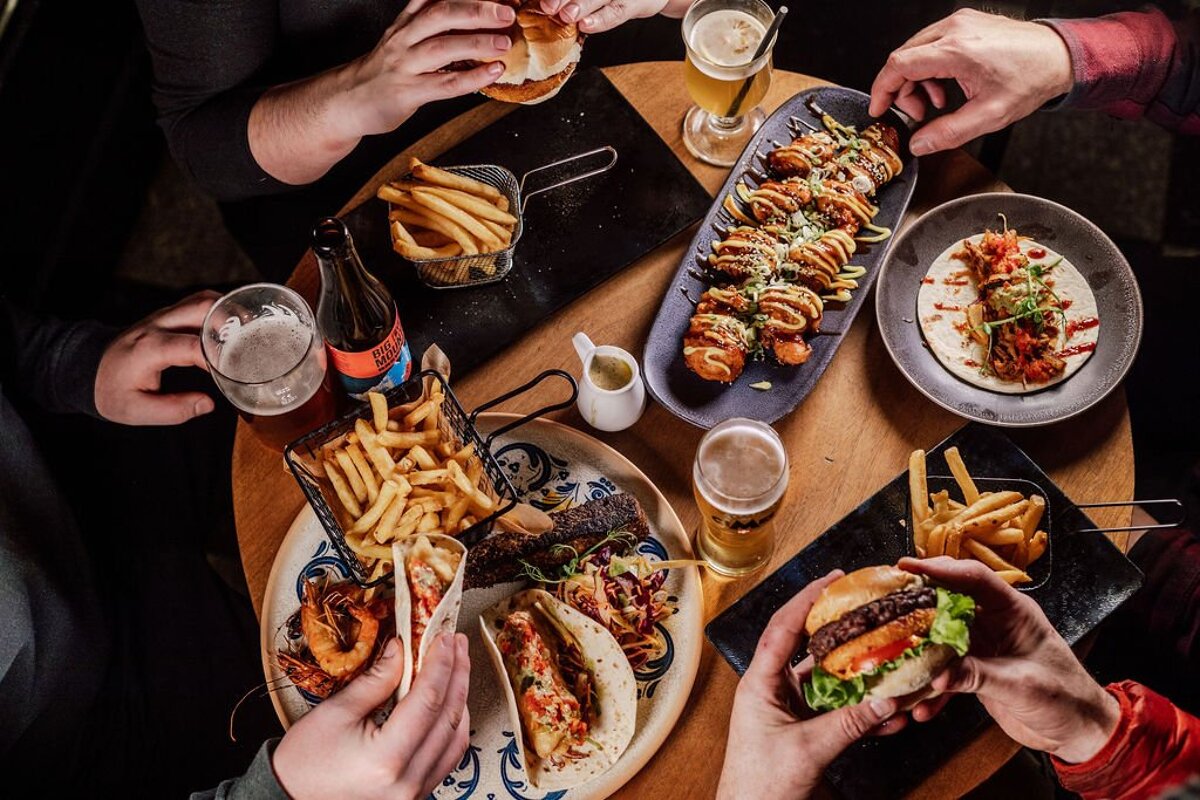 A table full of food and drinks including a bottle of pepsi