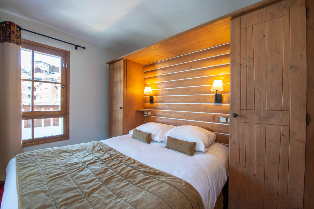 A bedroom with a bed and a wooden wall