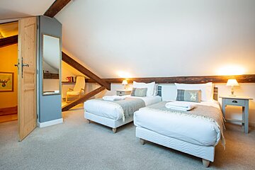 A bedroom with two twin beds and a mirror