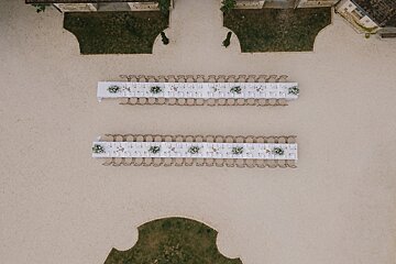 An aerial view of two long tables with flowers on them