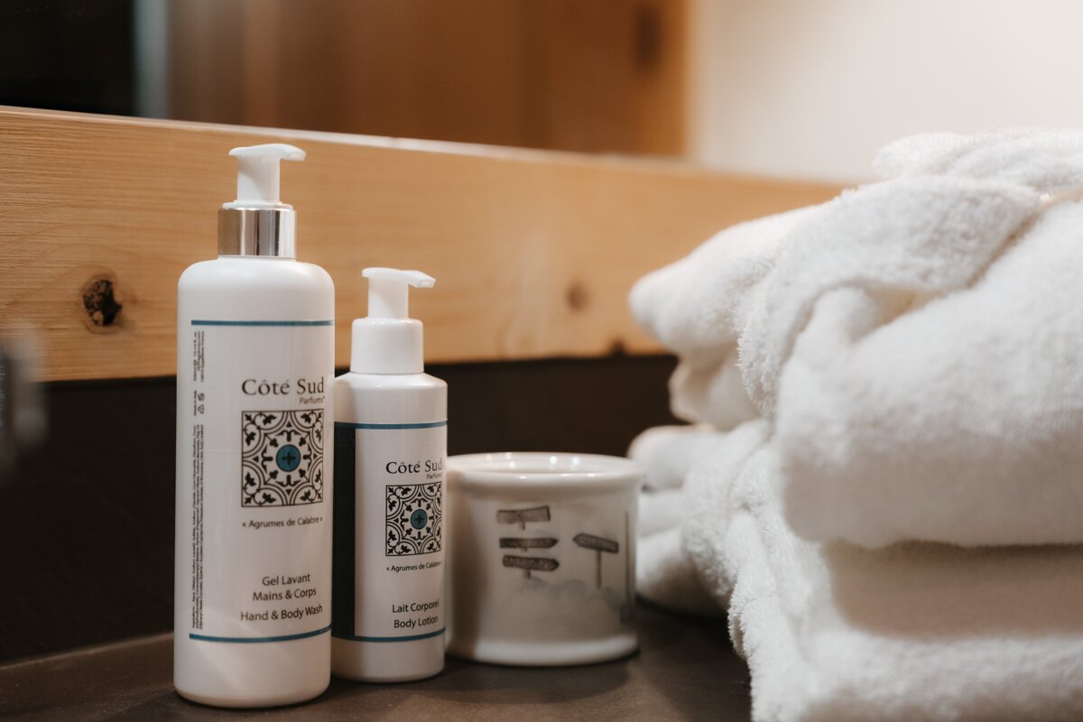 Three bottles of cote sud are on a bathroom counter