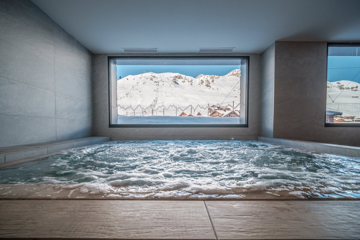 A hot tub with a view of a snowy mountain