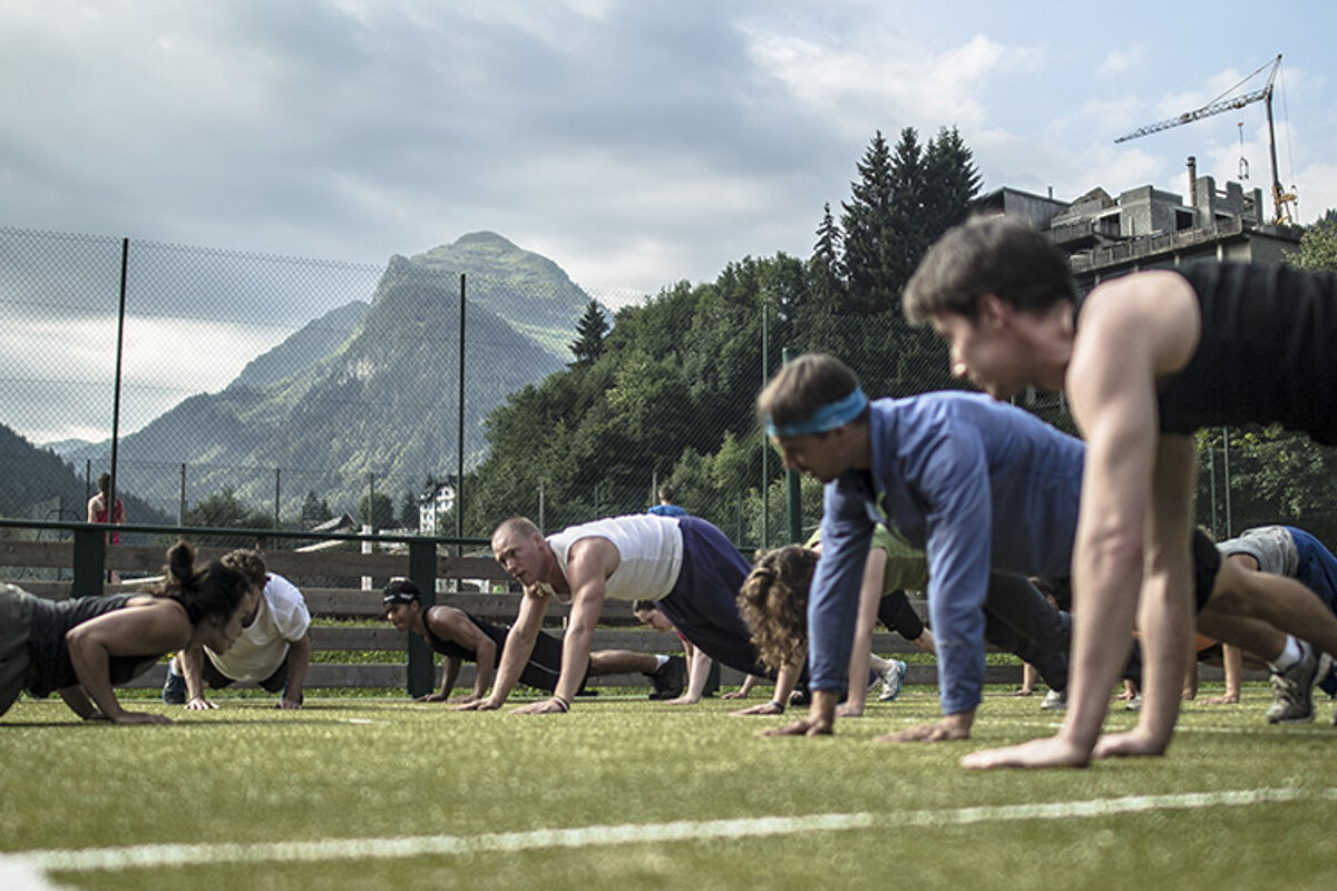 people doing press ups on a tennis court