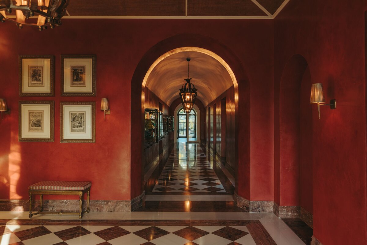 A hallway with red walls and a checkered floor