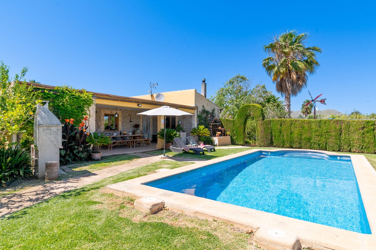 A house with a large swimming pool in front of it
