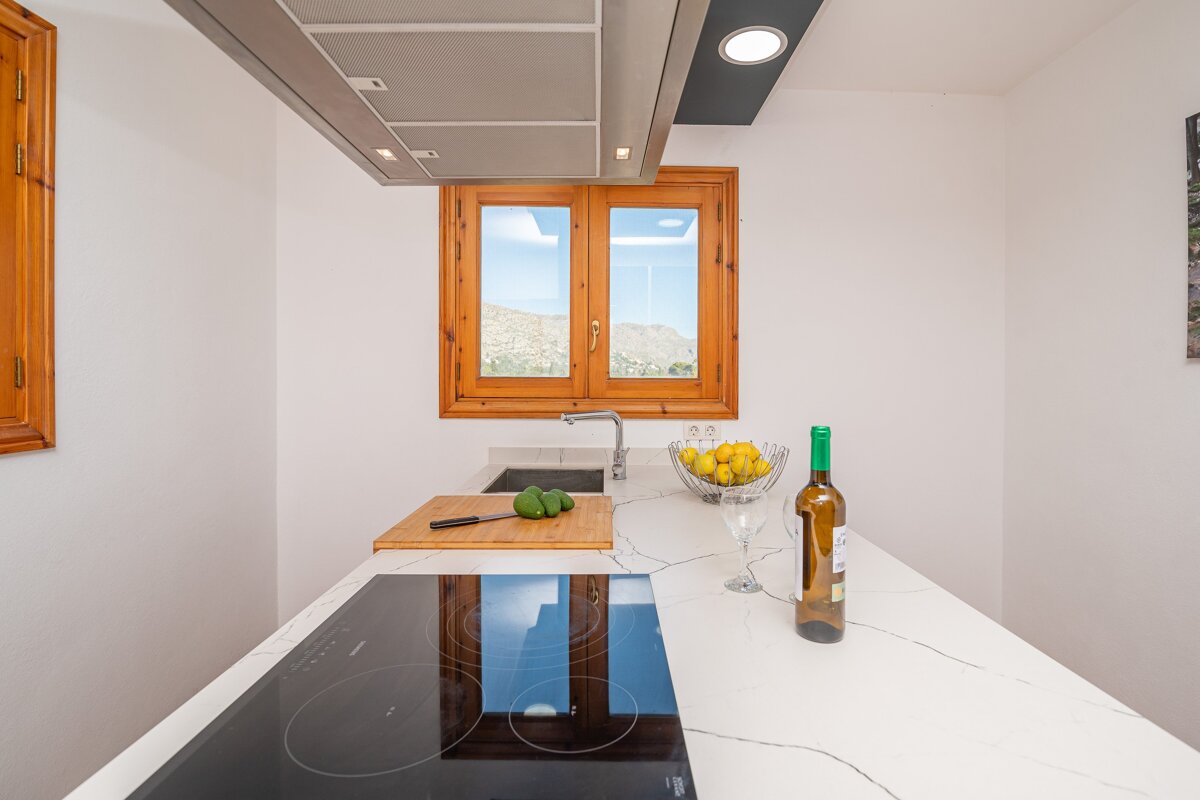 A bottle of wine sits on a counter in a kitchen