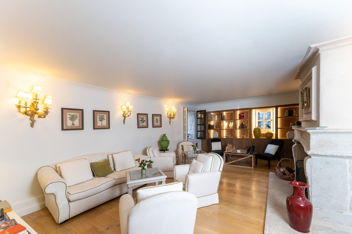 A living room with white furniture and a fireplace