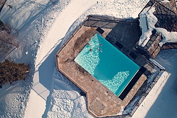 An aerial view of a swimming pool surrounded by snow