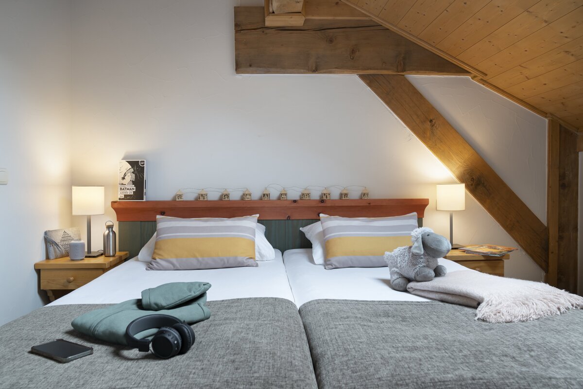A bedroom with two beds and a book on the wall that says ' sheep '