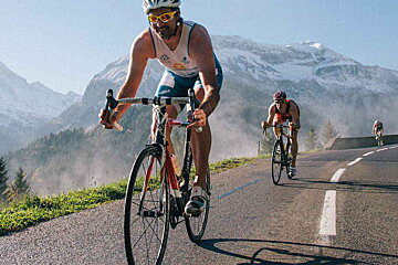 A man riding a bike with a shirt that says ' allianz ' on it