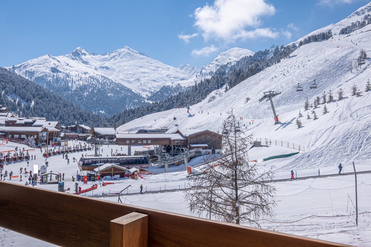 A view of a ski resort with mountains in the background