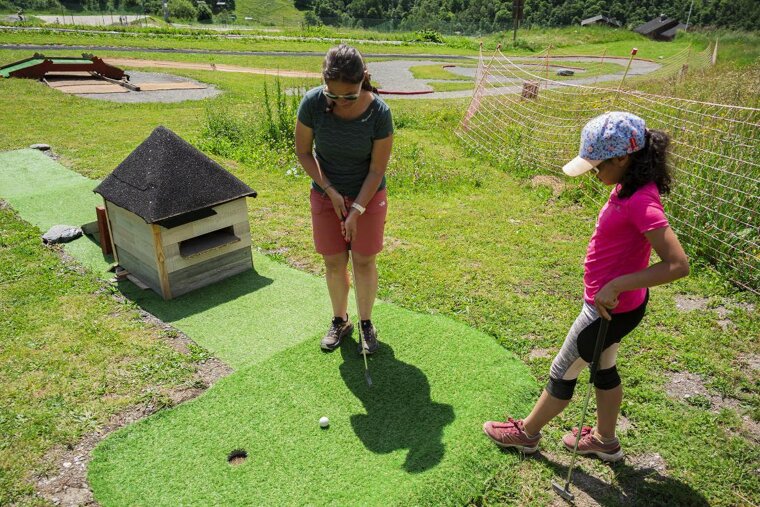 Mum and daughter playing on the mini golf course at Les Menuires, Val Thorens