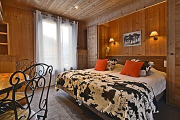 A bedroom with two beds and a picture of horses on the wall