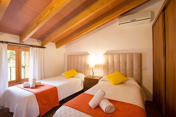 A bedroom with two twin beds and a window