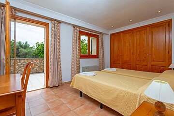 A bedroom with two beds and a desk