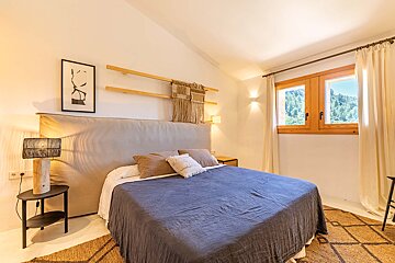 A bedroom with a large bed and a window