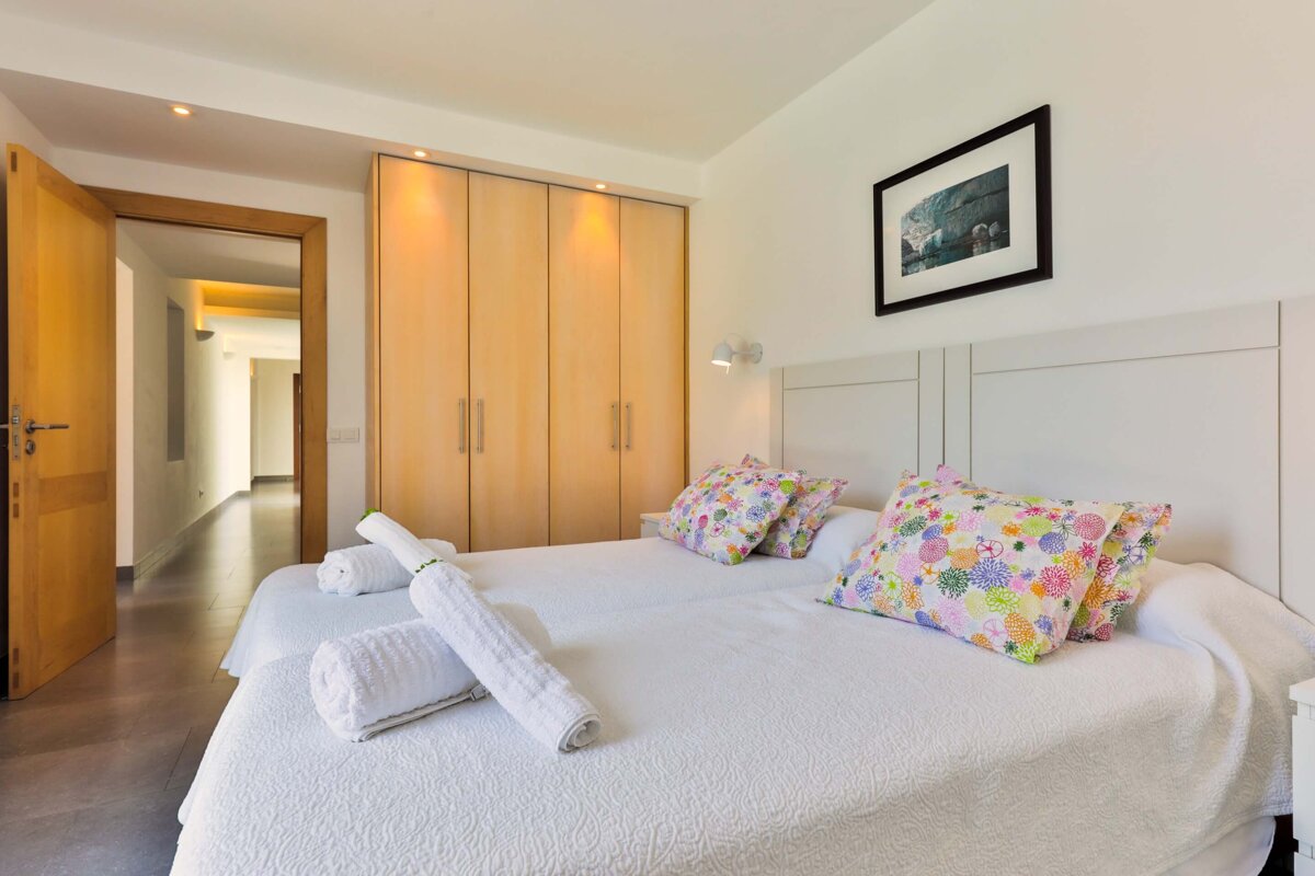 A bedroom with two beds and a picture on the wall